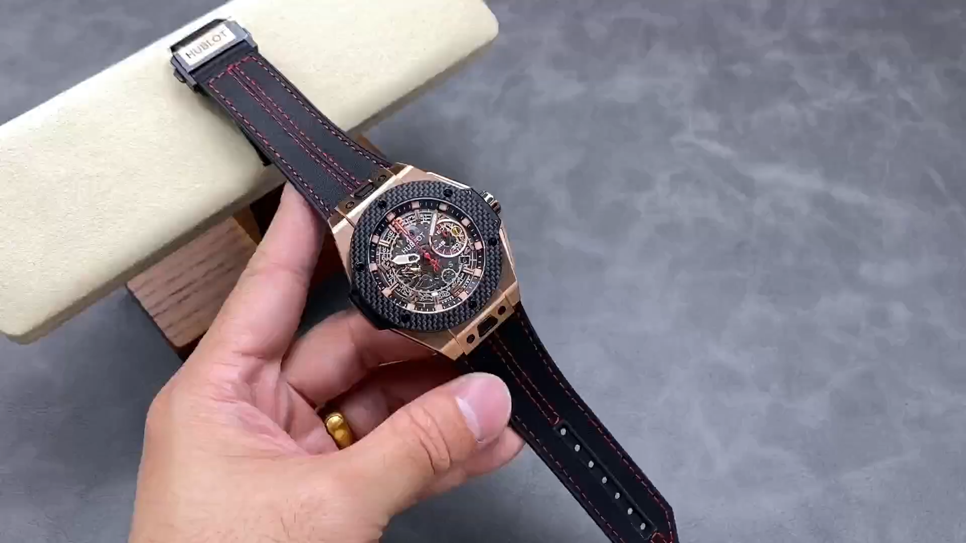 Strap in hand: Hublot Big Bang Unico Ferrari 401.OX.0123.VR showing black strap with red stitching. - Video