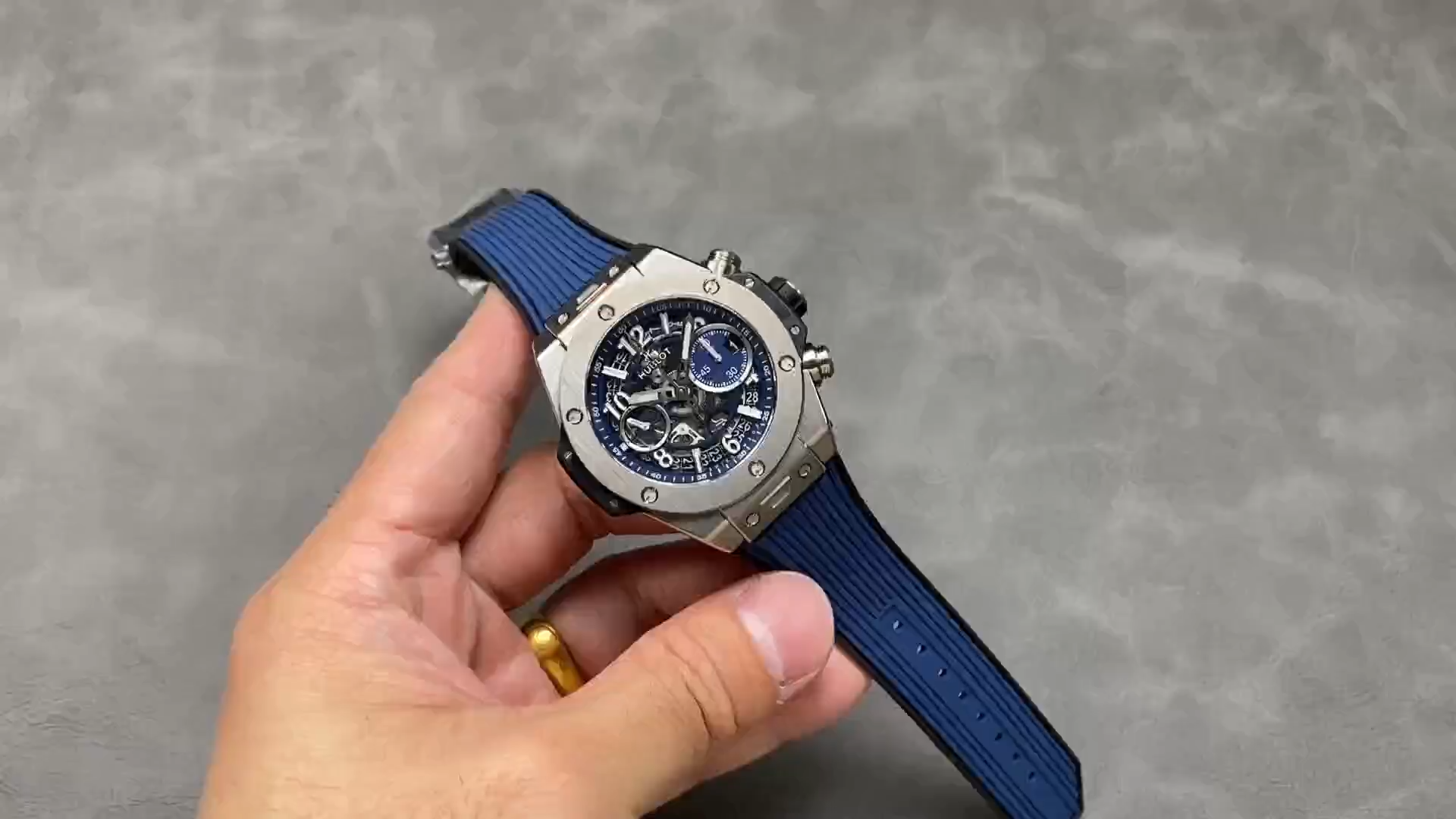 Strap in hand: Hublot Big Bang Unico 441.NX.5171.RX showing blue rubber strap laid out. - Video