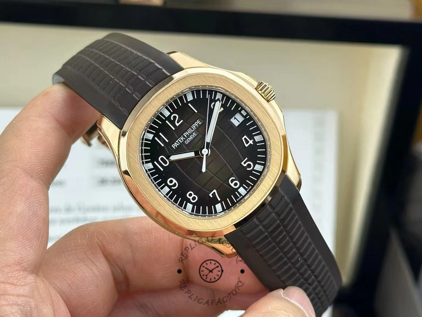 Hand-held watch : Patek Philippe Aquanaut 5167R-001 showing brown dial layout and strap grooves.