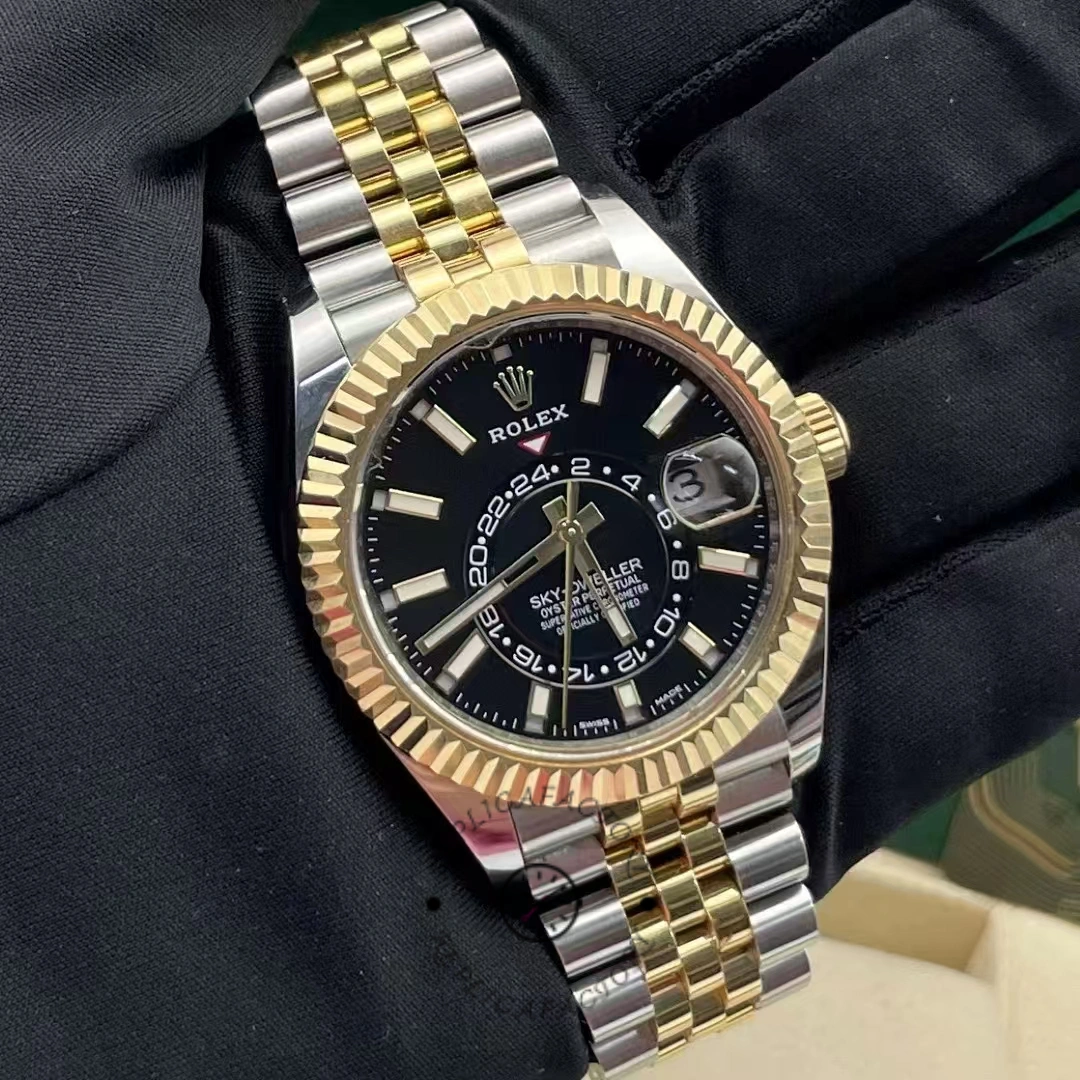 Wrist-style view of Rolex Sky-Dweller 326933, black dial and fluted yellow gold bezel on two-tone bracelet.