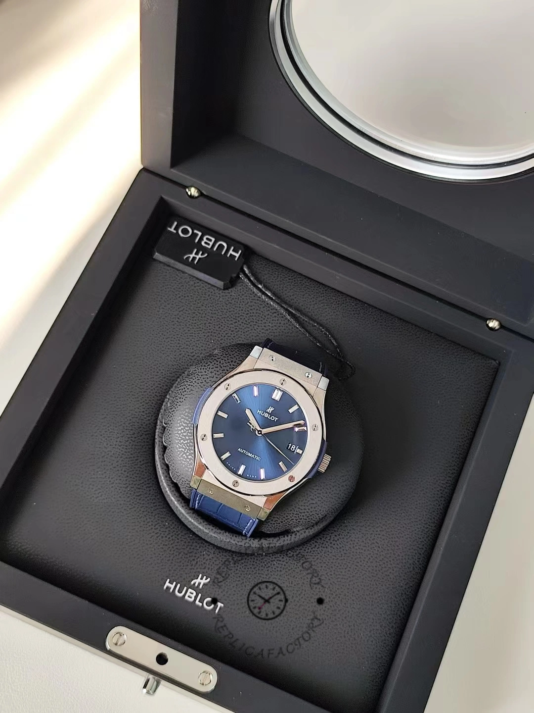Watch on box close-up: Hublot Classic Fusion 542.NX.7170.LR with blue dial and polished bezel edge.