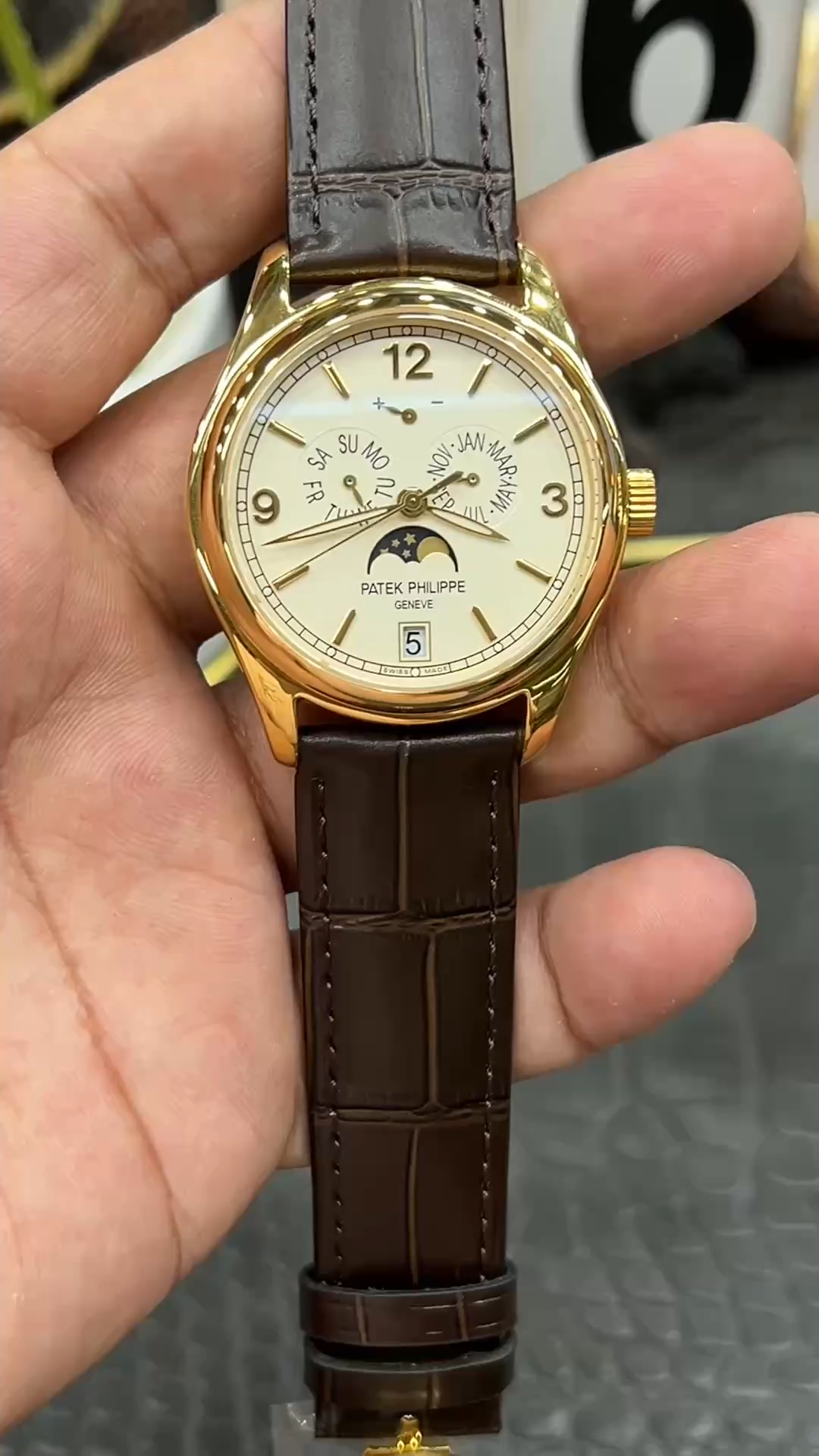 Handheld shot of the Patek Philippe 5146R-001, full dial layout with day-date-month and moonphase display. - Video