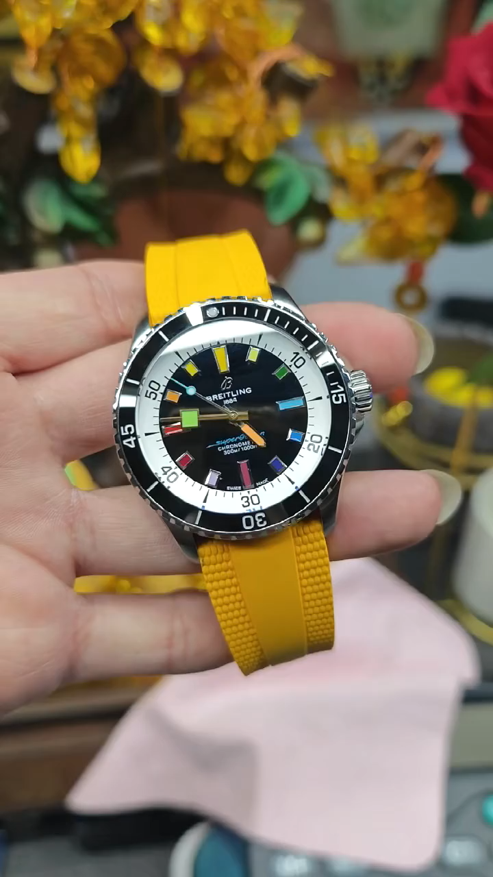 Video: hand-held Breitling Superocean Automatic A17375211B2S4 showing yellow rubber strap and dial in daylight. - Video