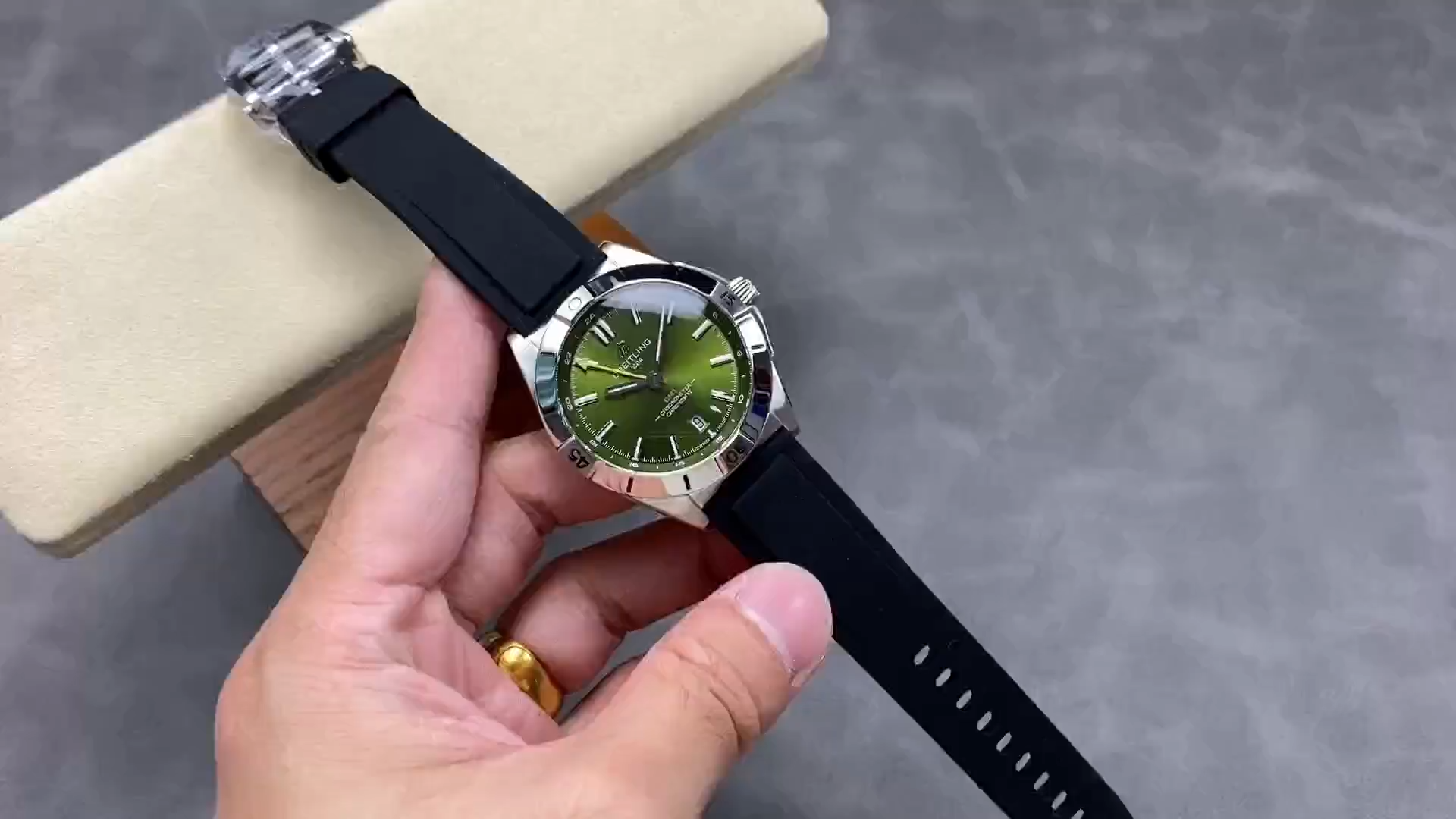 Breitling Chronomat GMT 40 A32398A11L1A1, video showing green dial and black rubber strap, on cushion. - Video