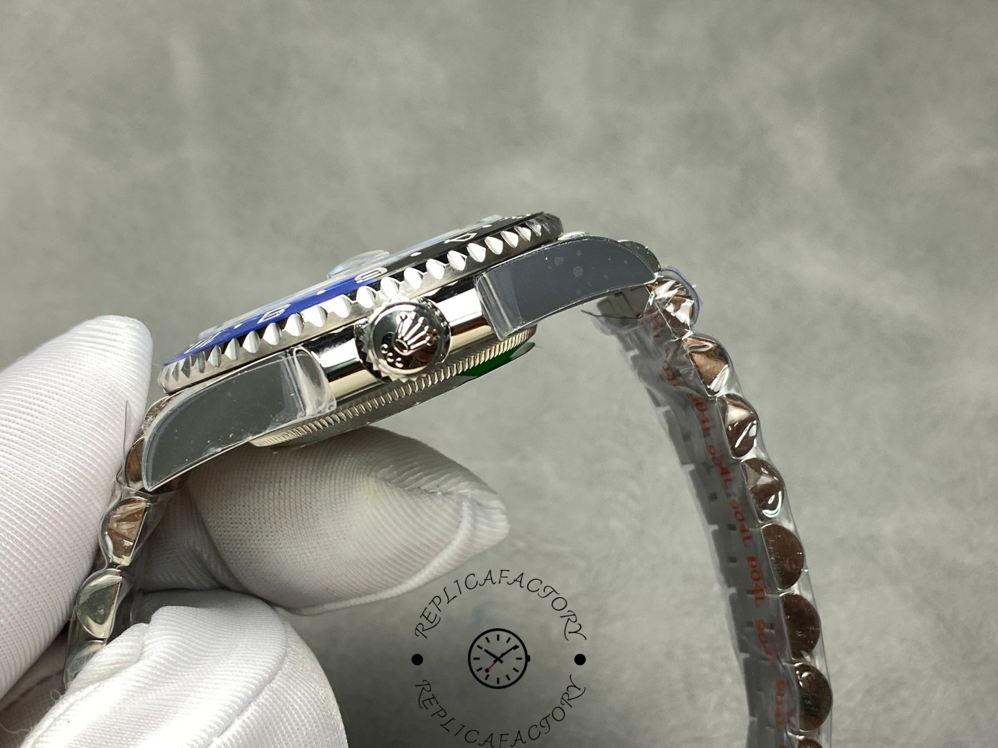Rolex GMT-Master II 126710BLNR crown-side view, case profile and end links, held in glove.