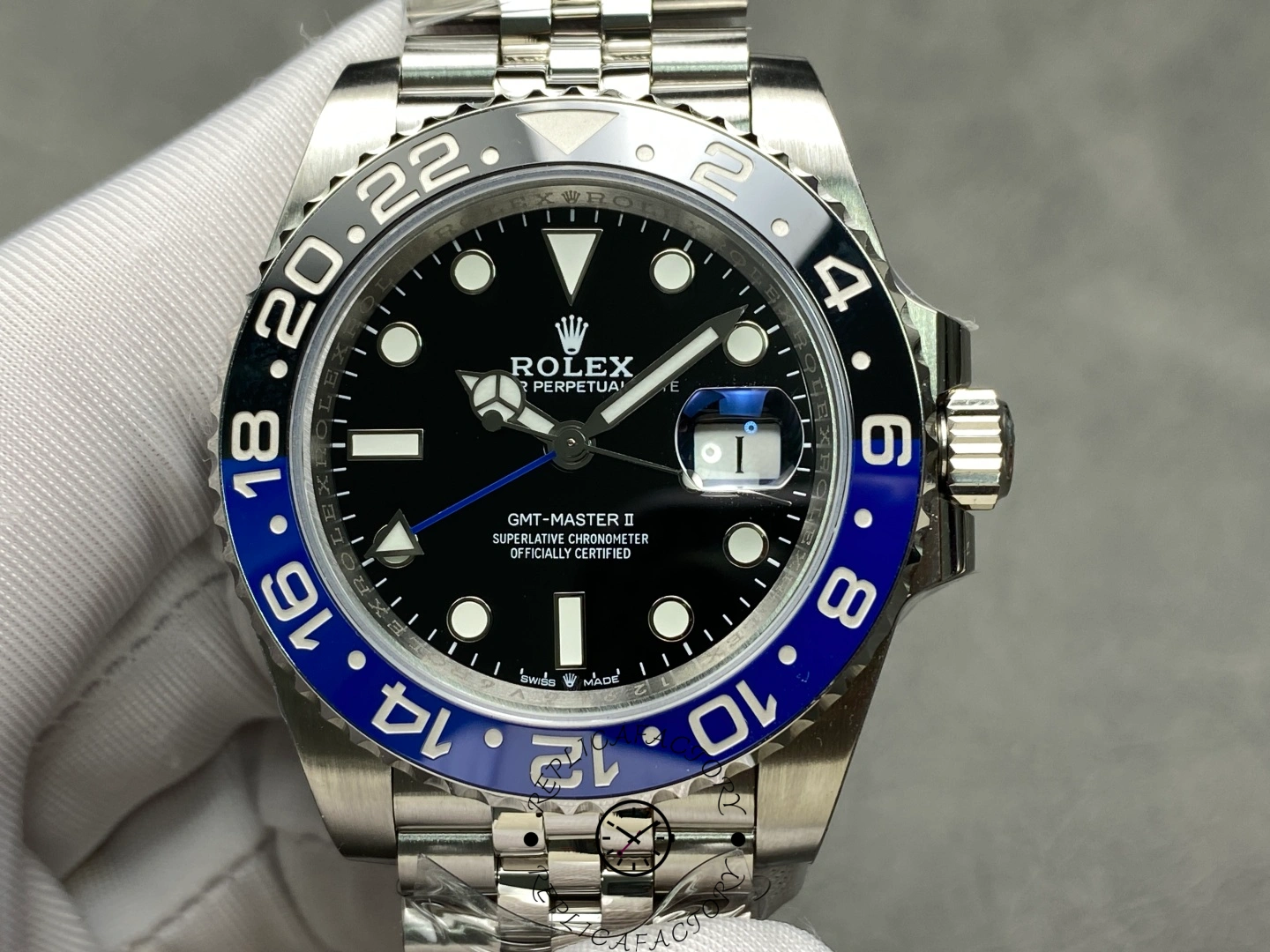 Rolex GMT-Master II 126710BLNR held in glove, black dial and Batman bezel, Jubilee bracelet.
