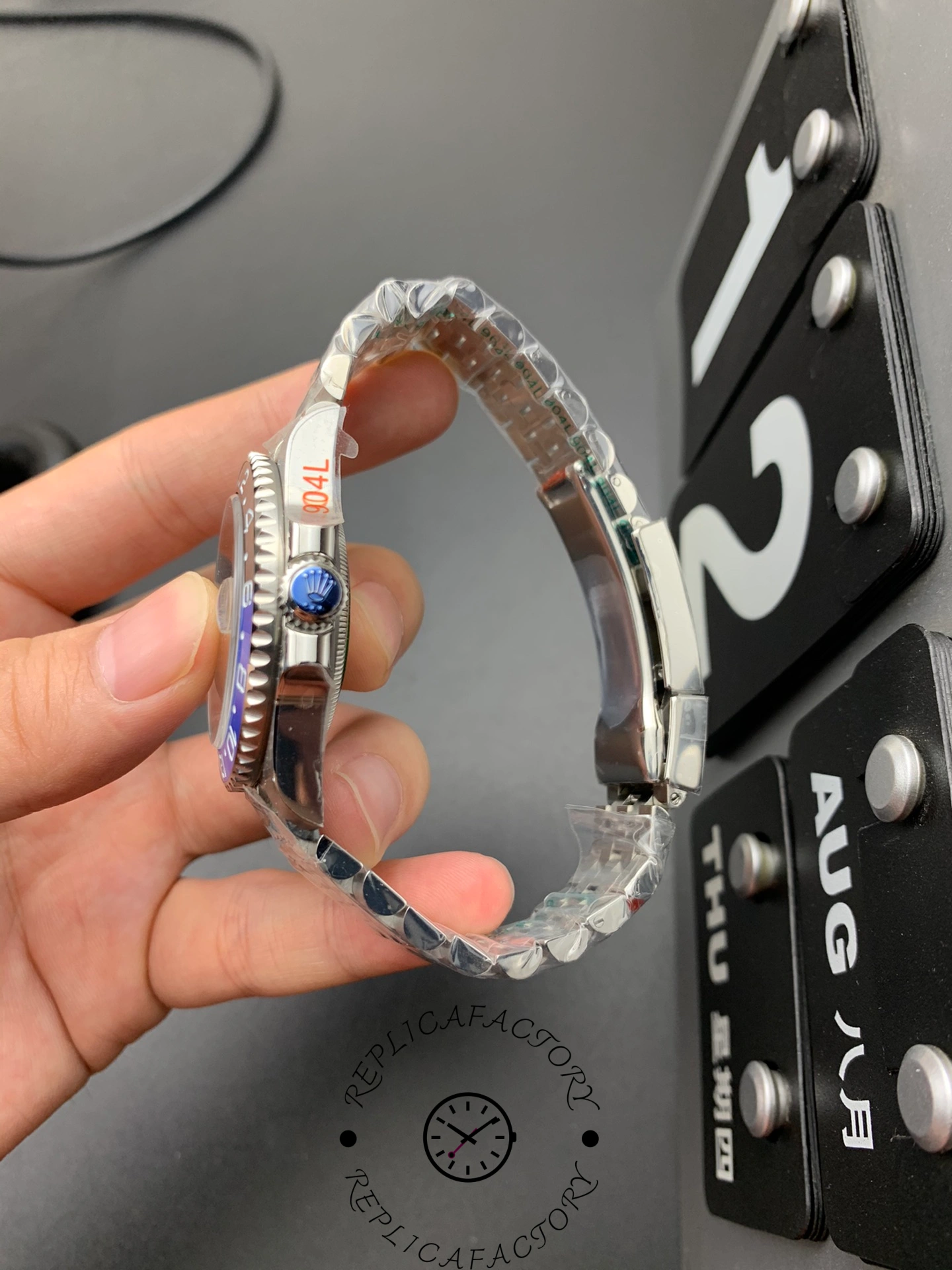 Rolex GMT-Master II 126710BLNR side view in hand, crown with engraved Rolex logo.