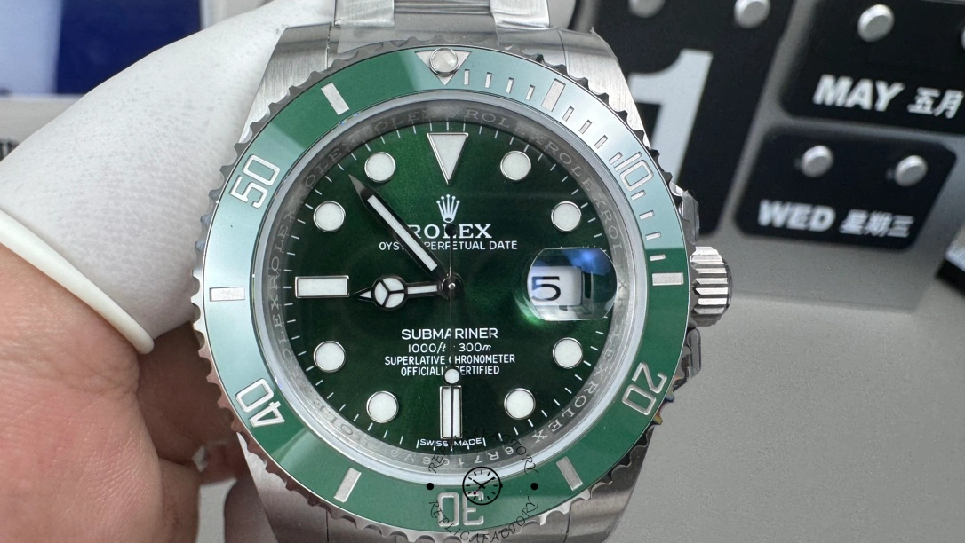 Rolex Submariner 116610LV, green dial, close-up front view on gloved hand.