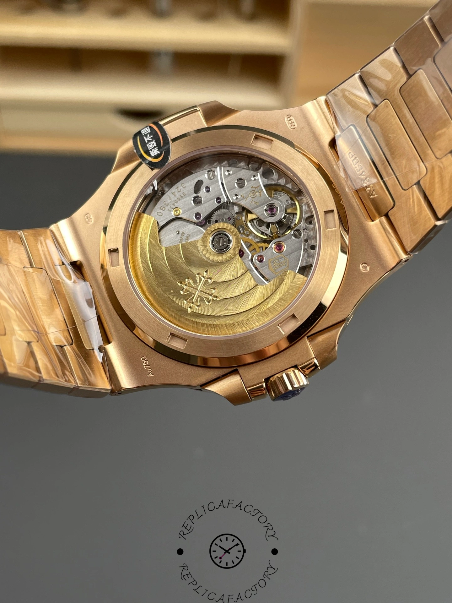 Exhibition caseback close-up of Patek Philippe Nautilus 5711/1R-001 showing gold rotor and engravings.
