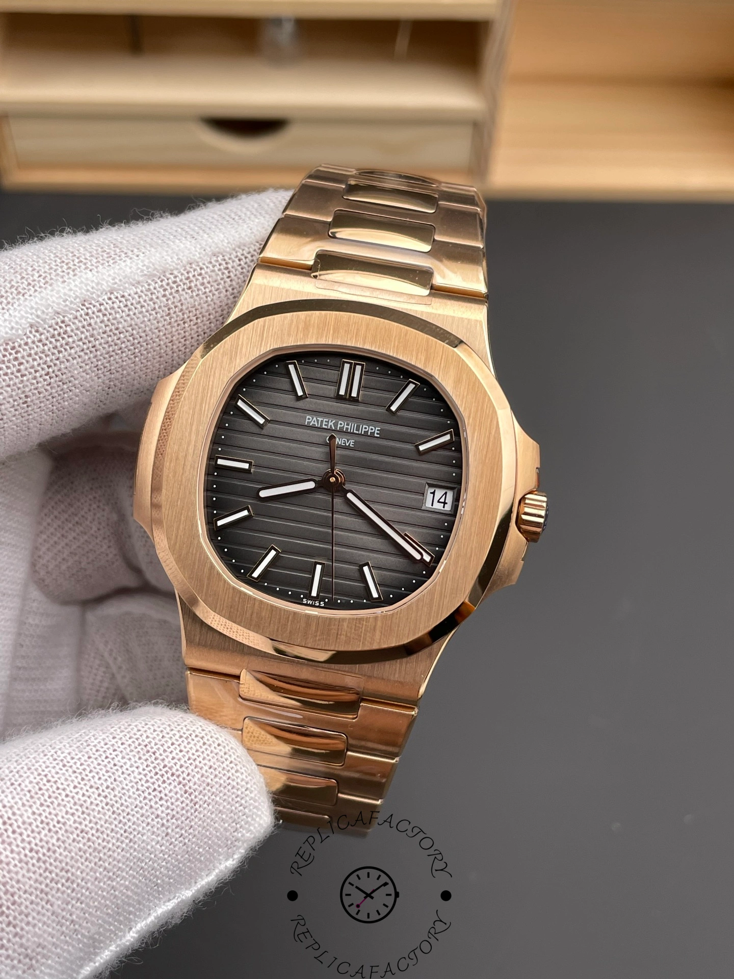 Hand-held close-up of Patek Philippe Nautilus 5711/1R-001 showing dial texture and date window.