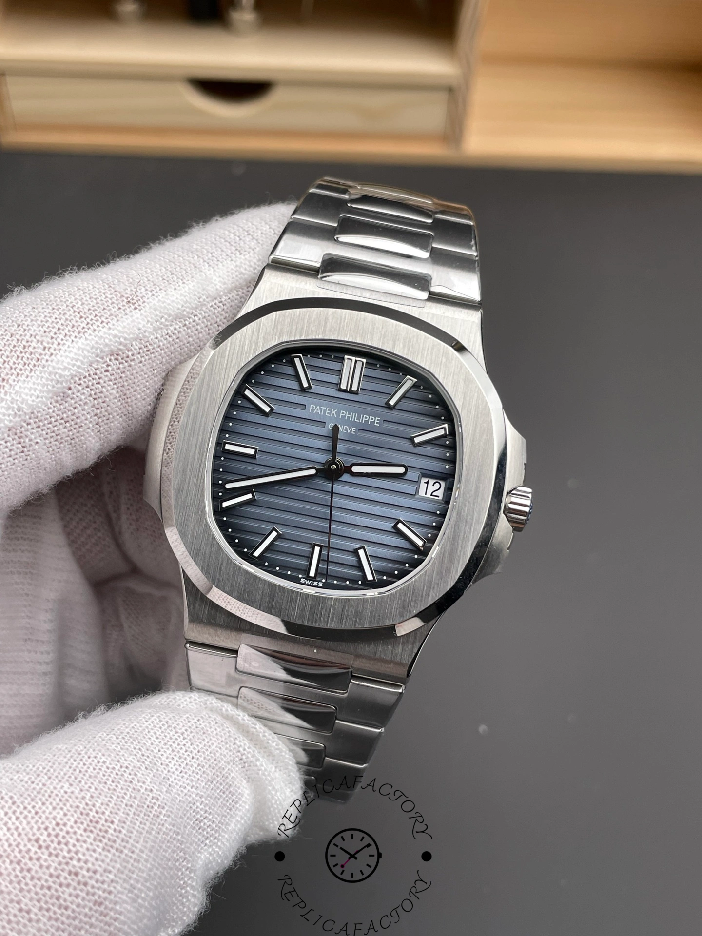 Hand-held front angle of Patek Philippe Nautilus 5711/1A showing bezel shape and case finishing.