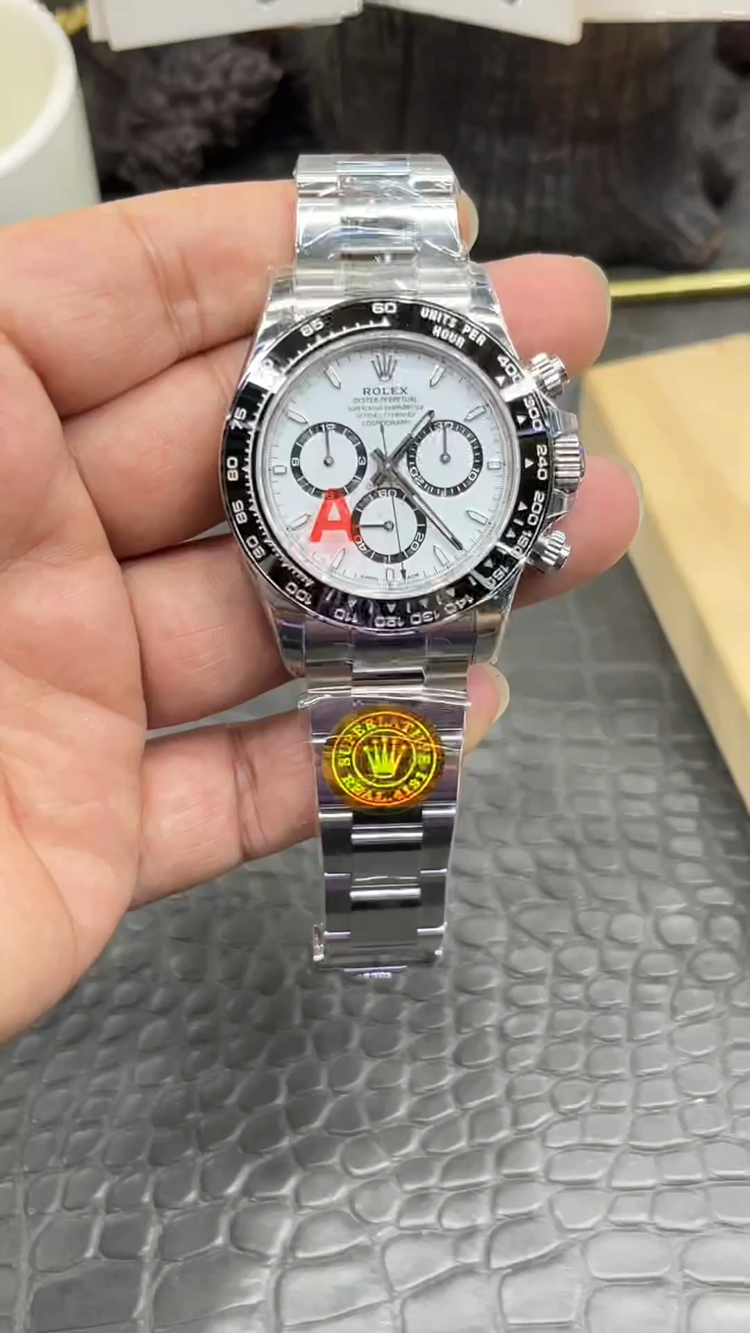 Rolex Daytona M126500LN-0001 video, handheld front view with stickers on dial.