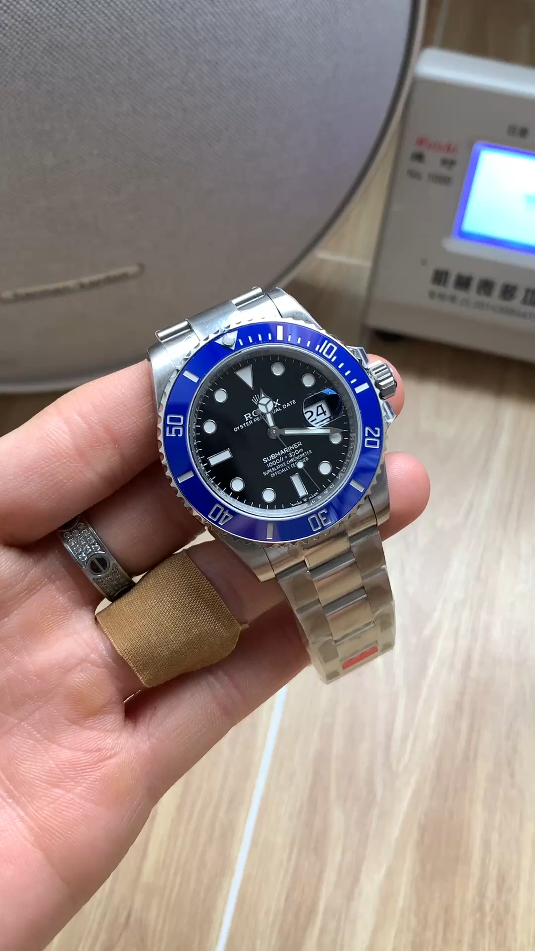 Rolex Submariner 126619LB 0003, bracelet held in hand showing clasp side.