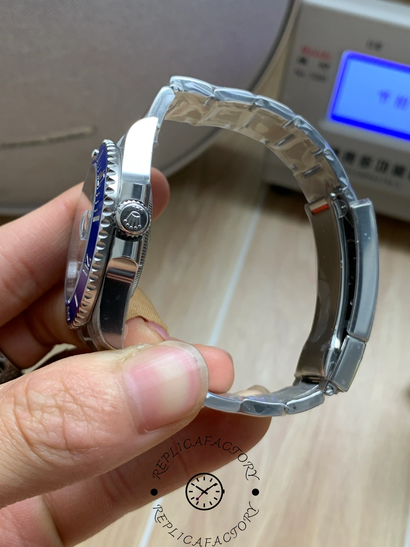Rolex Submariner 126619LB 0003, side view in hand showing crown guards.