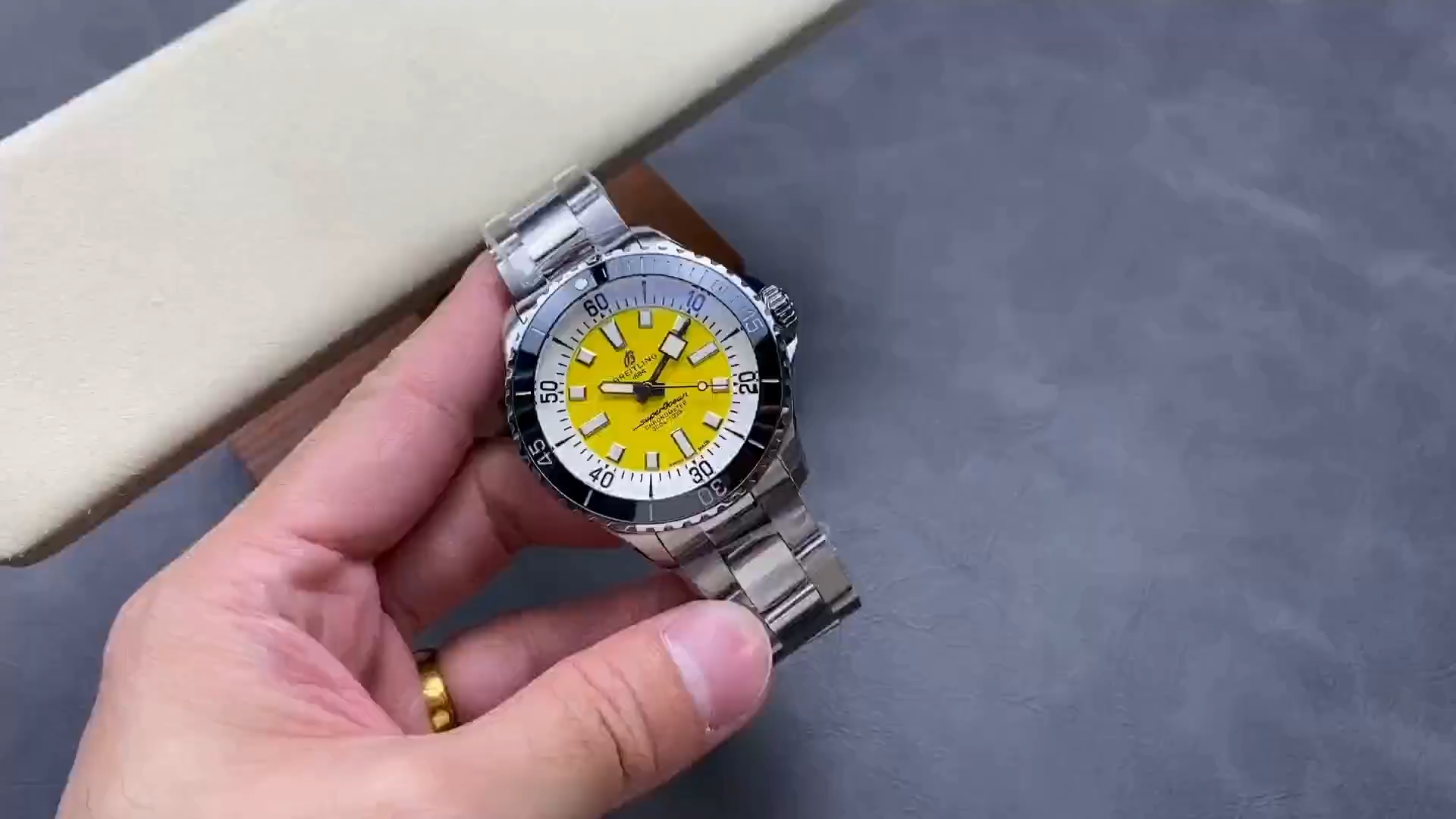 Video: hand-held Breitling Superocean Automatic A17375211I1A1 showing yellow dial and steel bracelet. - Video