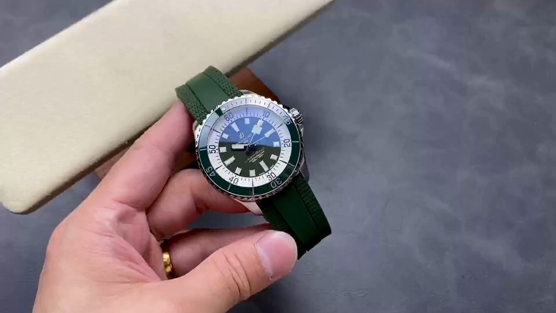 Video: hand-held Breitling Superocean Automatic A17376A31L1S1 showing green rubber strap and bezel. - Video