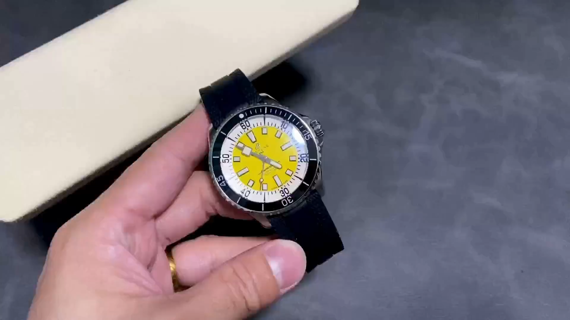 Video: hand-held Breitling Superocean Automatic A17375211I1S1 showing yellow dial and blue rubber strap. - Video