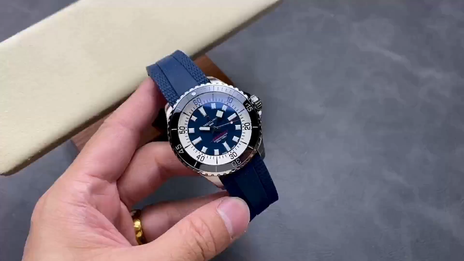Video: hand-held Breitling Superocean Automatic A17376211C1S1 showing blue rubber strap and bezel. - Video