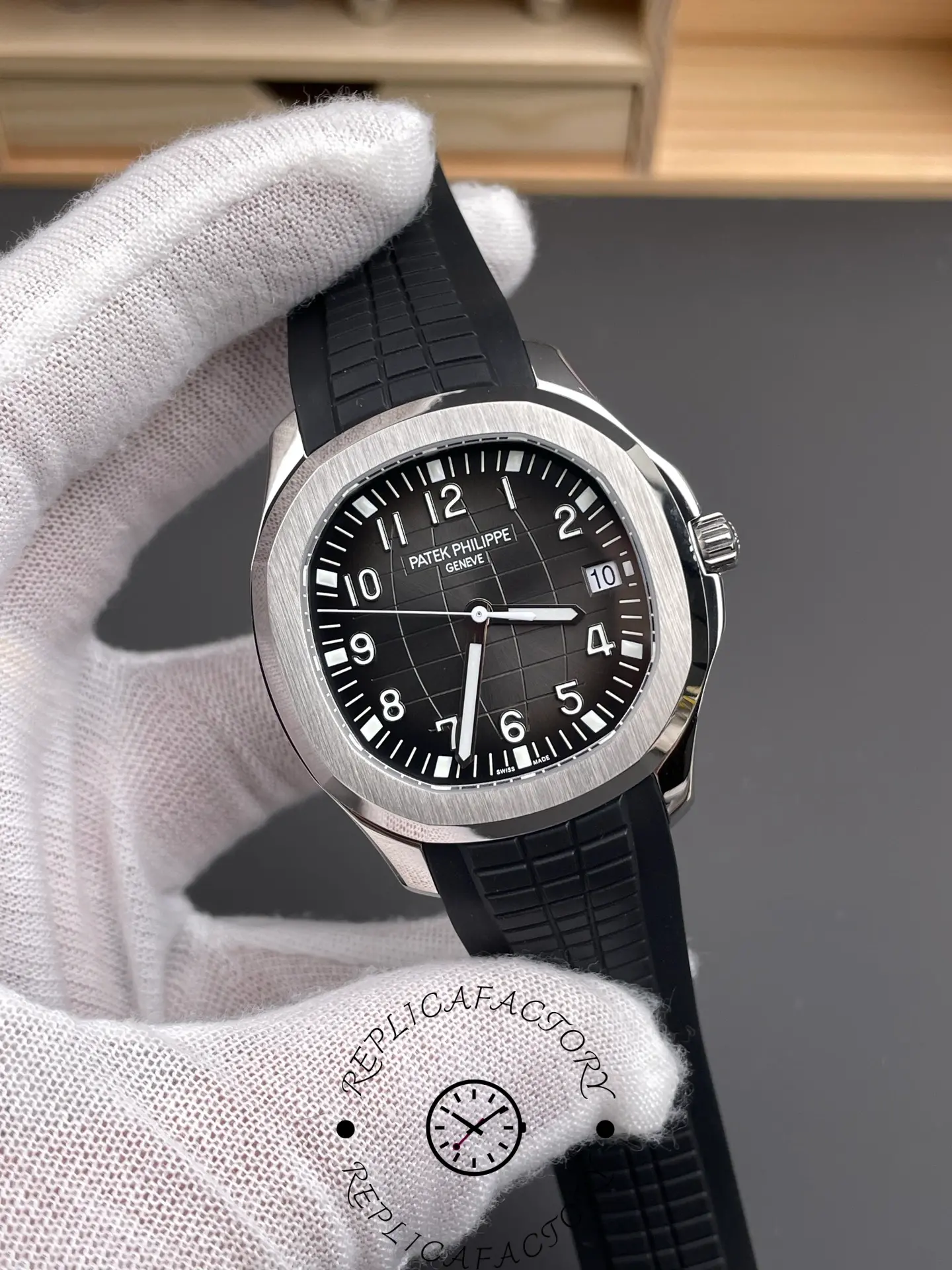 Angled close-up of Patek Philippe Aquanaut 5167A-001 showing luminous hands and Arabic numerals.
