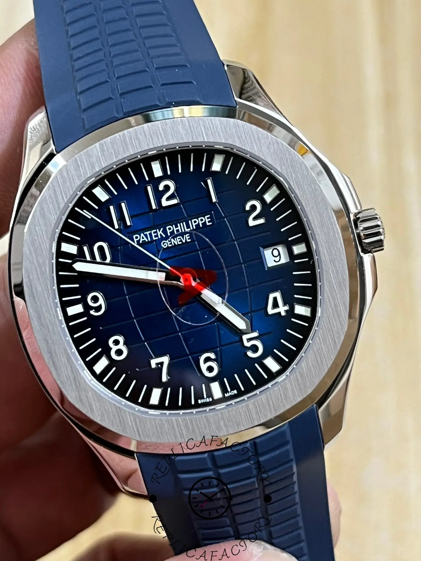 Hand-held close-up of Patek Philippe Aquanaut 5168G-001 showing dial depth and bezel shine.