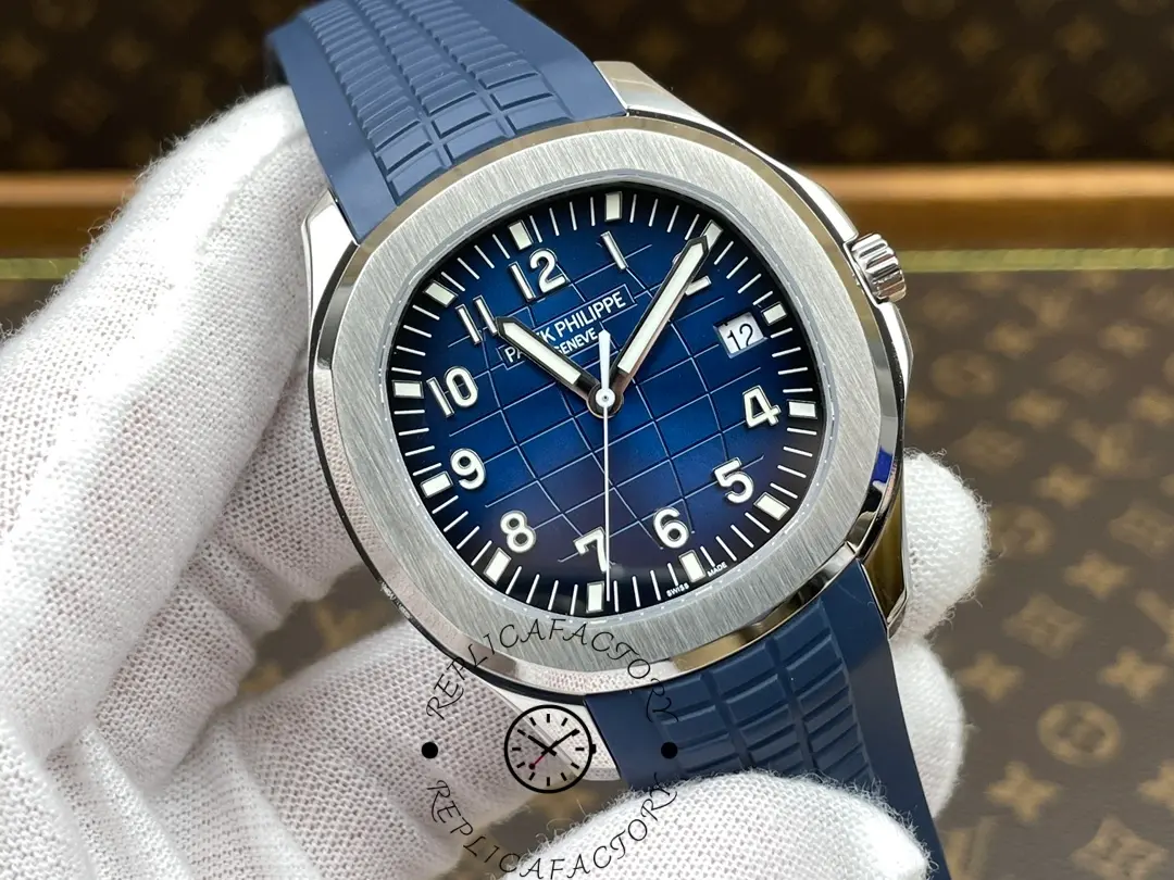 Hand-held close-up of Patek Philippe Aquanaut 5168G-001 showing blue dial texture and luminous markers.