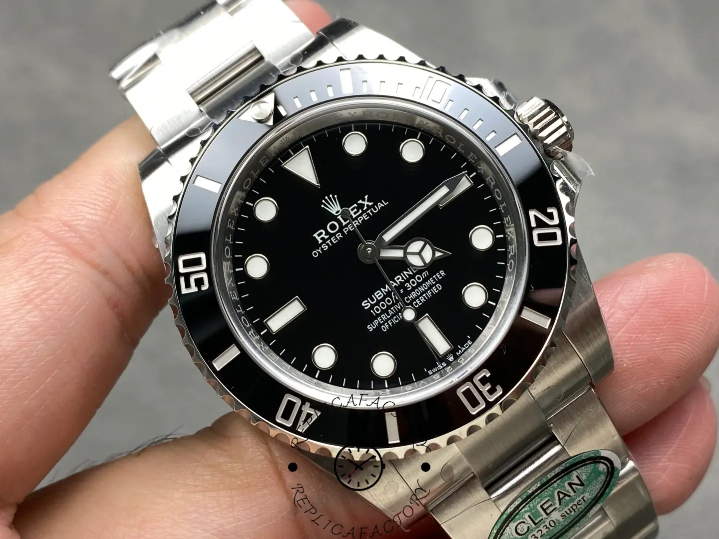 Rolex Submariner 124060, angled dial close-up in hand with Oyster bracelet.