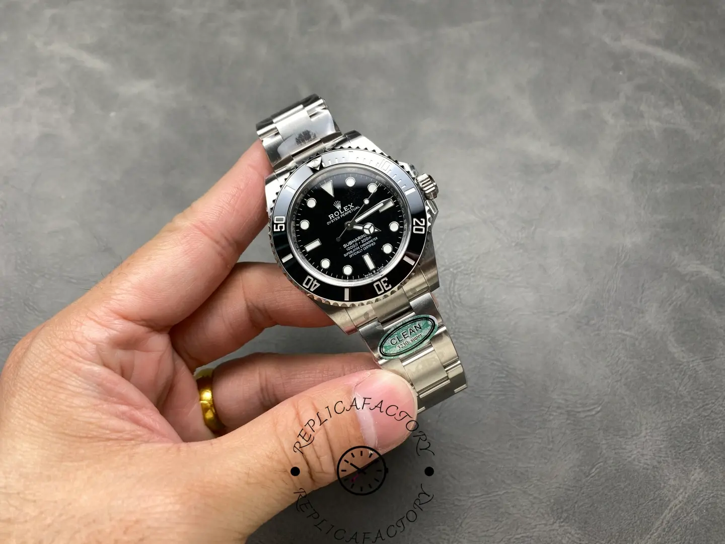 Rolex Submariner 124060, full watch held in hand, black dial.