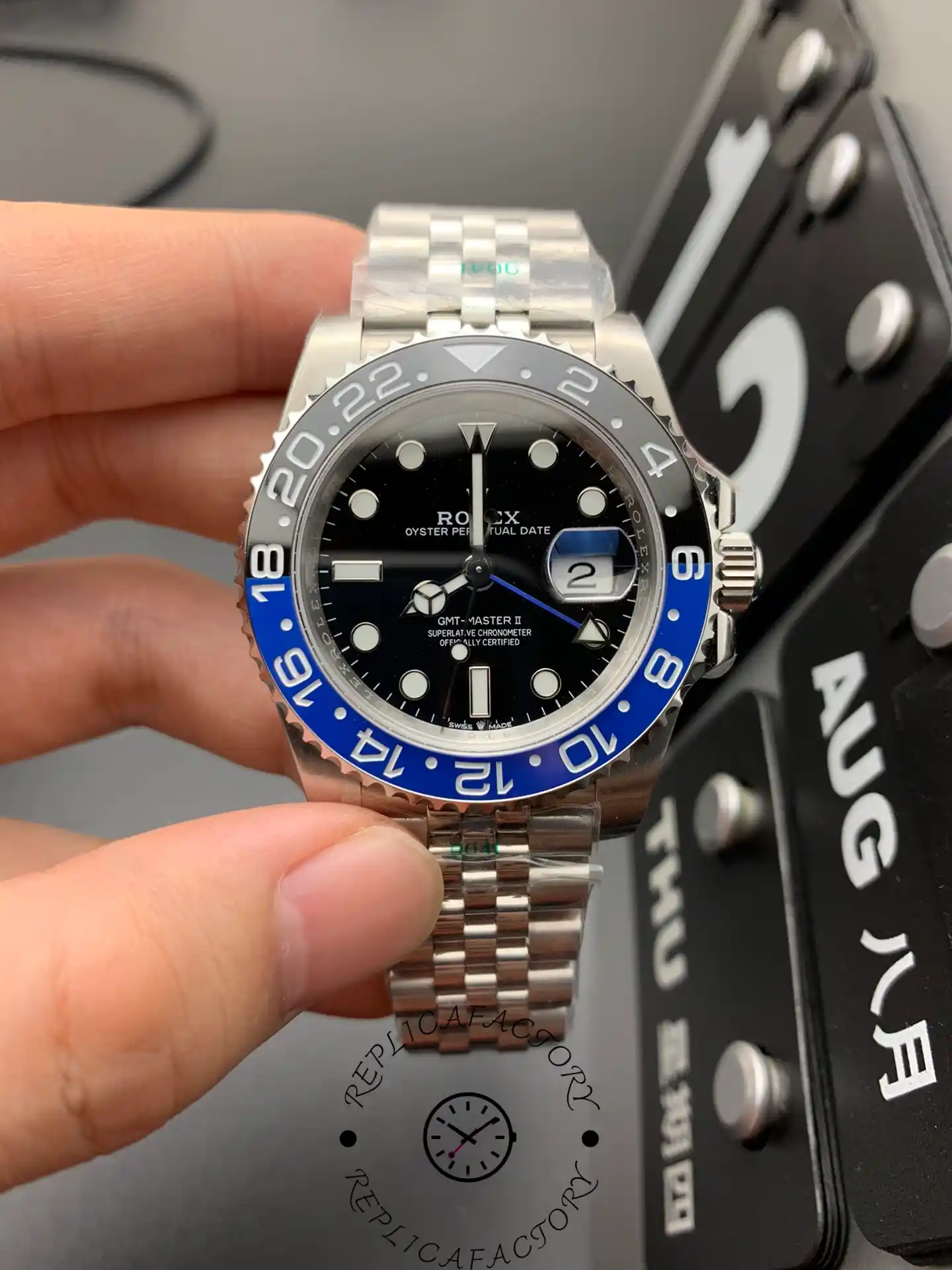 Rolex GMT-Master II 126710BLNR held in hand, black dial and Batman bezel, Jubilee bracelet.