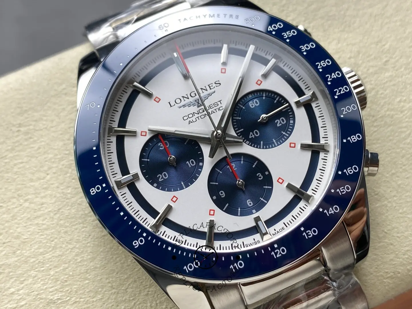 Longines Conquest Chronograph L3.835.4.98.6, angled close-up of silver dial with blue subdials and tachymeter bezel.