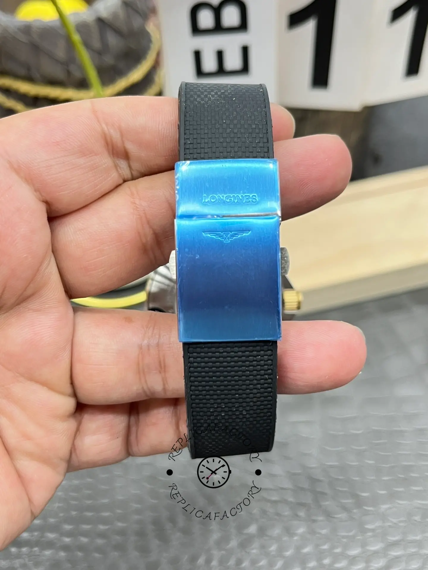 Bracelet clasp of Longines HydroConquest L3.781.3.56.9 with blue protective film and logo.