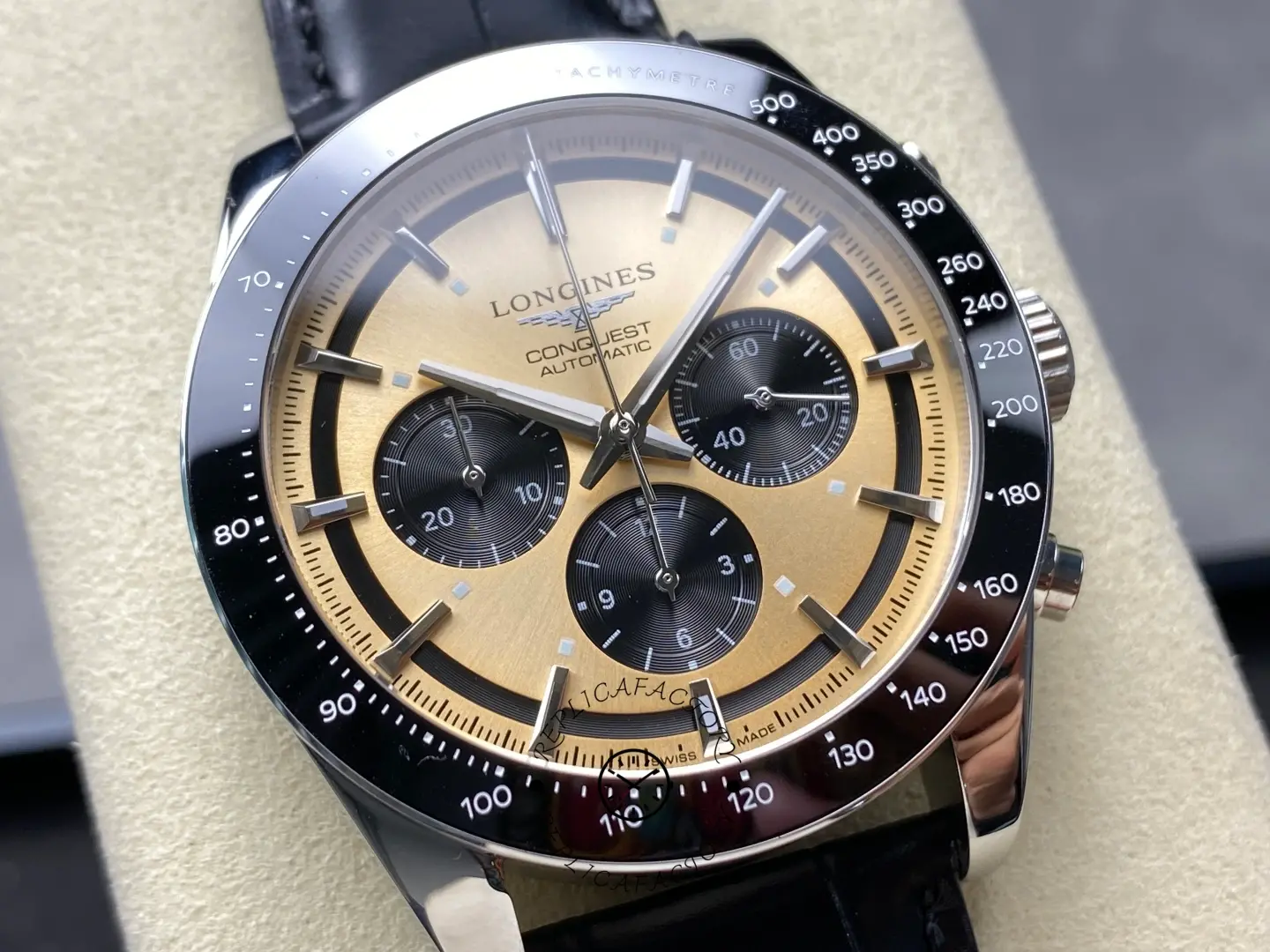 Longines L3.835.4.32.9 dial close-up, gold chronograph face with black subdials and tachymeter scale.