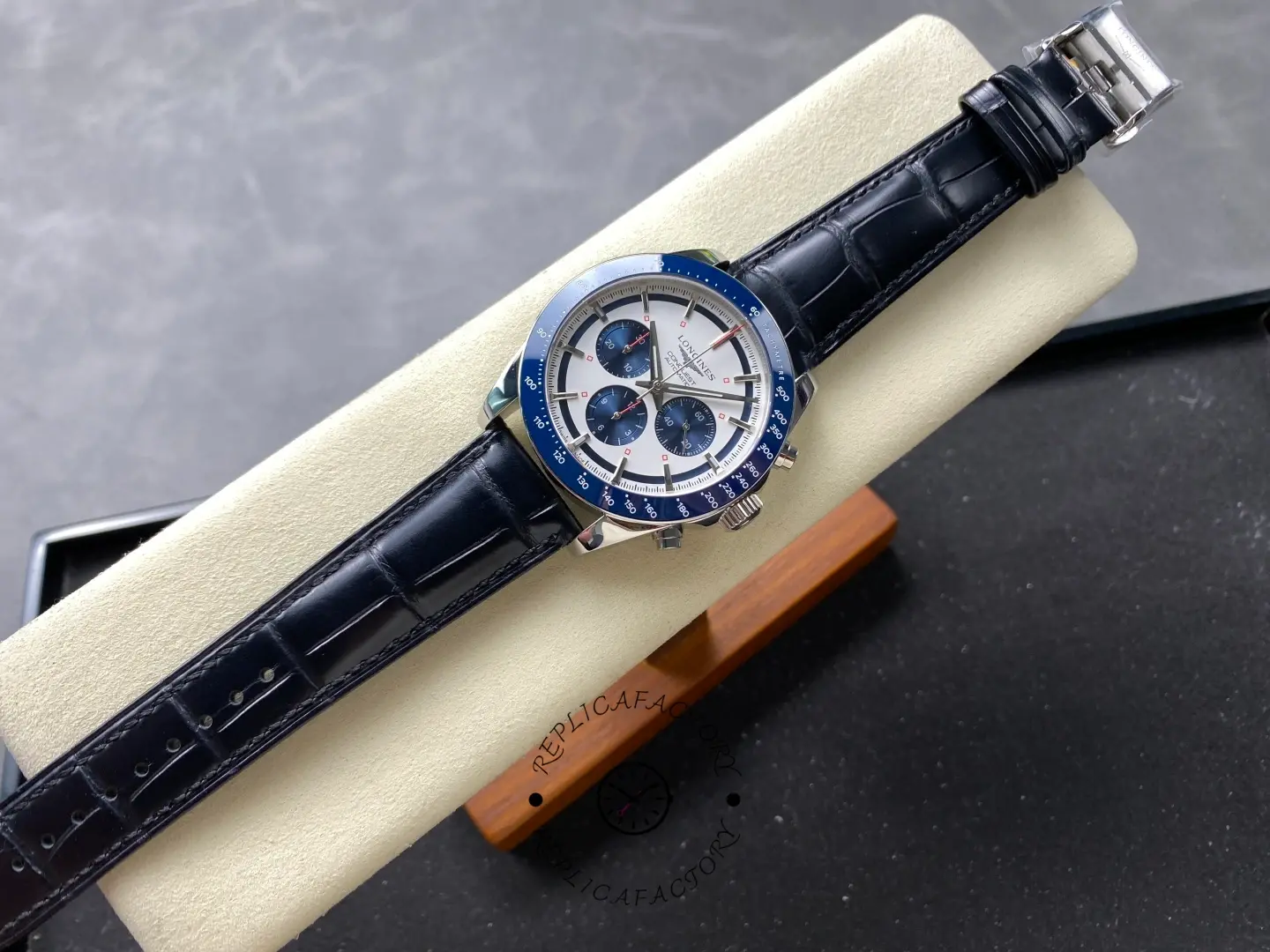 Longines Conquest Chronograph L3.835.4.98.9, full view with black leather strap laid flat on display stand.