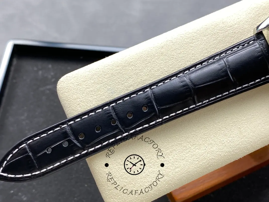 Strap detail of Longines L2.673.4.78.3 showing black leather strap holes and white stitching.