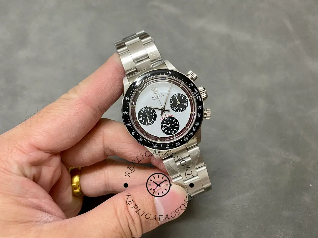 Side profile of Rolex Daytona 6241 in hand, showing white exotic Paul Newman dial with steel bracelet.