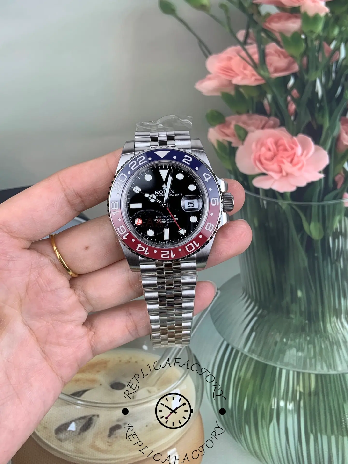 Hand holding Rolex GMT-Master II 126710BLRO with Pepsi bezel and Jubilee bracelet, full watch view.