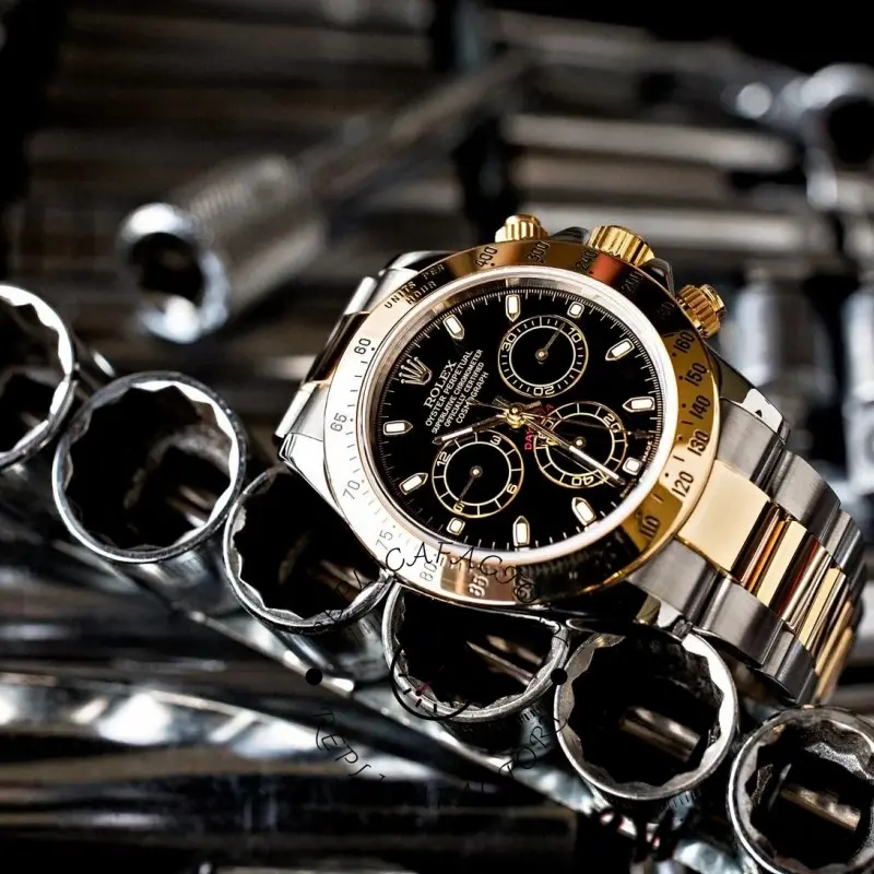 Lifestyle view of Rolex Daytona 116523 showing black dial and two-tone bracelet on metal background.